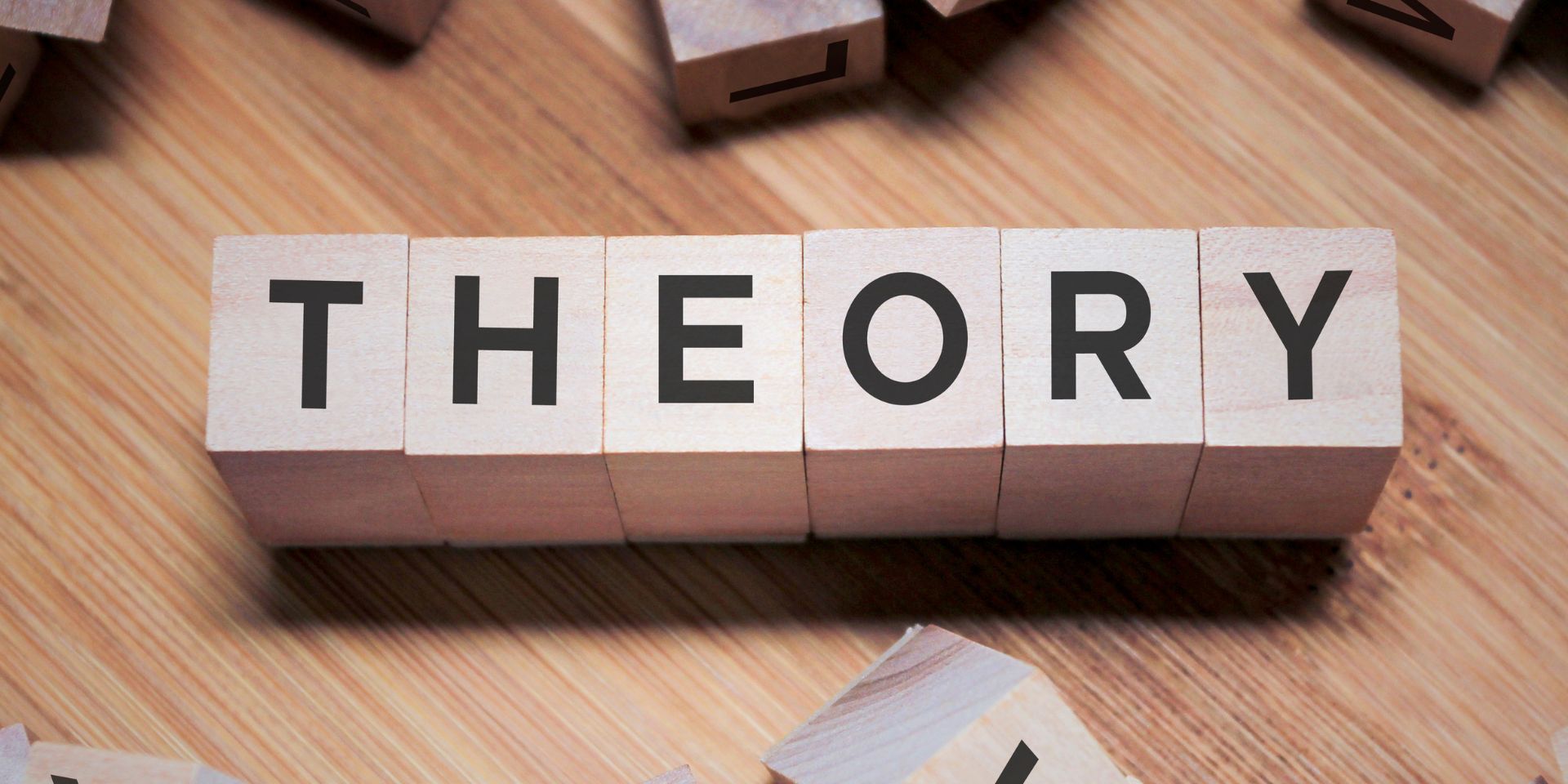 Wooden block letters spell out the word 'theory'.