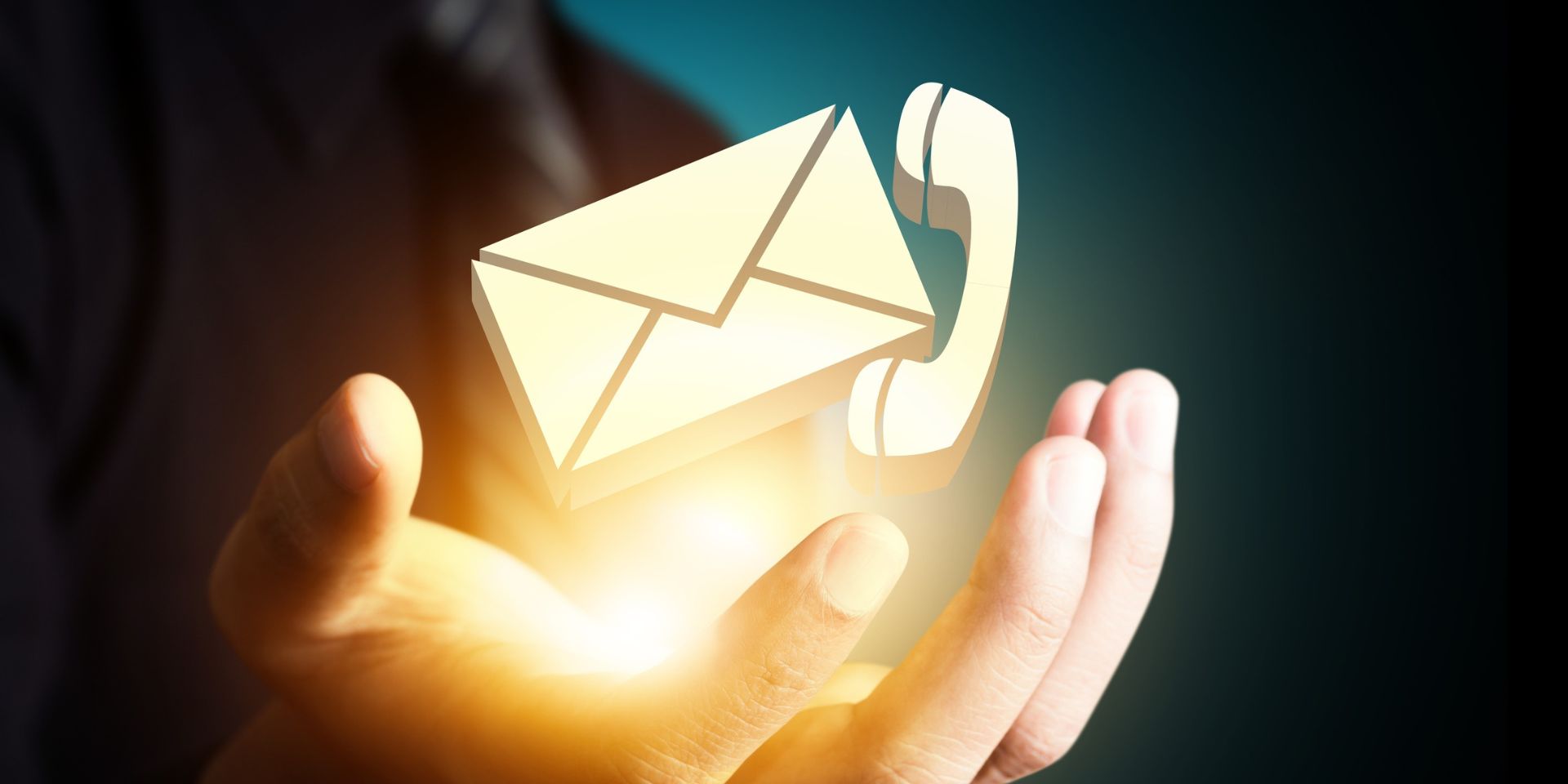 A man holds glowing email and telephone icons.