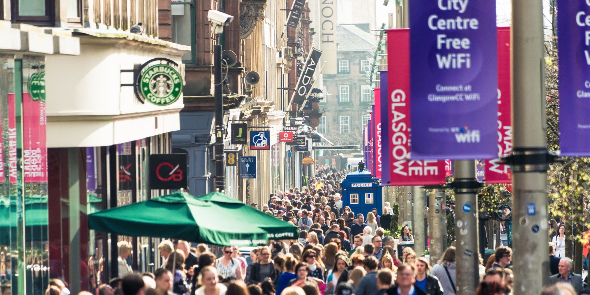 A UK high street full of people shopping.